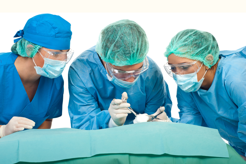 Three surgeons  in sterile uniforms  operating in a surgery room isolated on white background